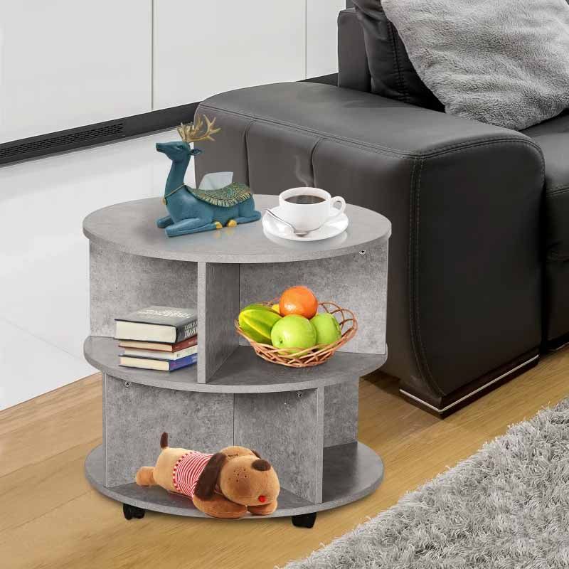Round gray side table with books, a bowl of fruit, and a toy in a living room setting.