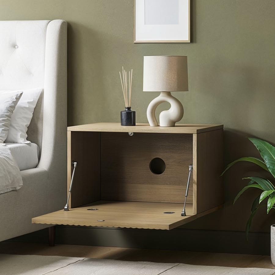 Wooden nightstand with lamp and decor items next to a bed in a bedroom setting.