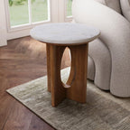Small round table with marble top and wooden base in a living room setting.