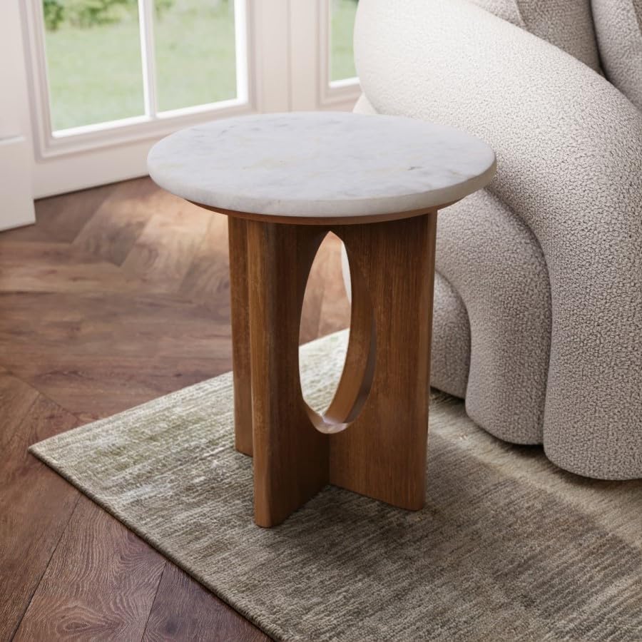 Small round table with marble top and wooden base in a living room setting.