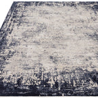 Textured area rug with a mix of dark and light colors on a plain background