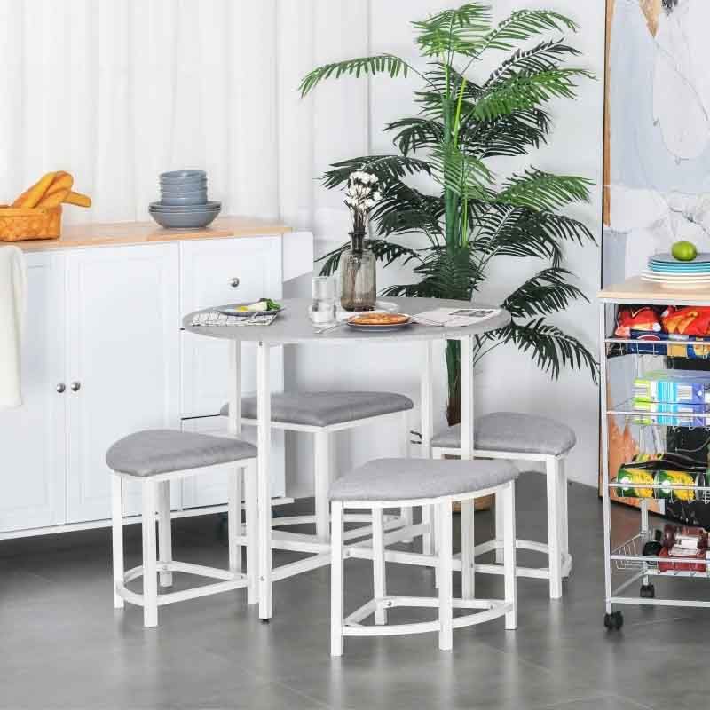 White dining table with four gray cushioned stools in a kitchen setting.