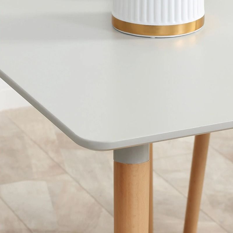 White table with wooden legs on a light wood floor