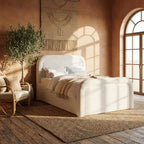 White upholstered bed in a cozy bedroom with wooden floor and decorative elements.