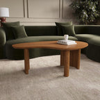Wooden coffee table in a living room with a green sofa and decorative items.