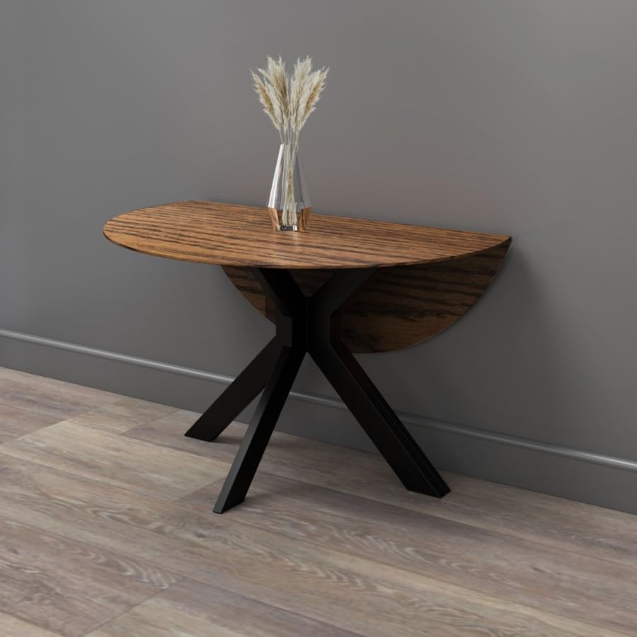 Wooden dining table with black legs against a gray wall
