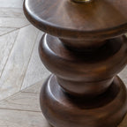 Wooden side table with a rustic finish on a wooden floor.