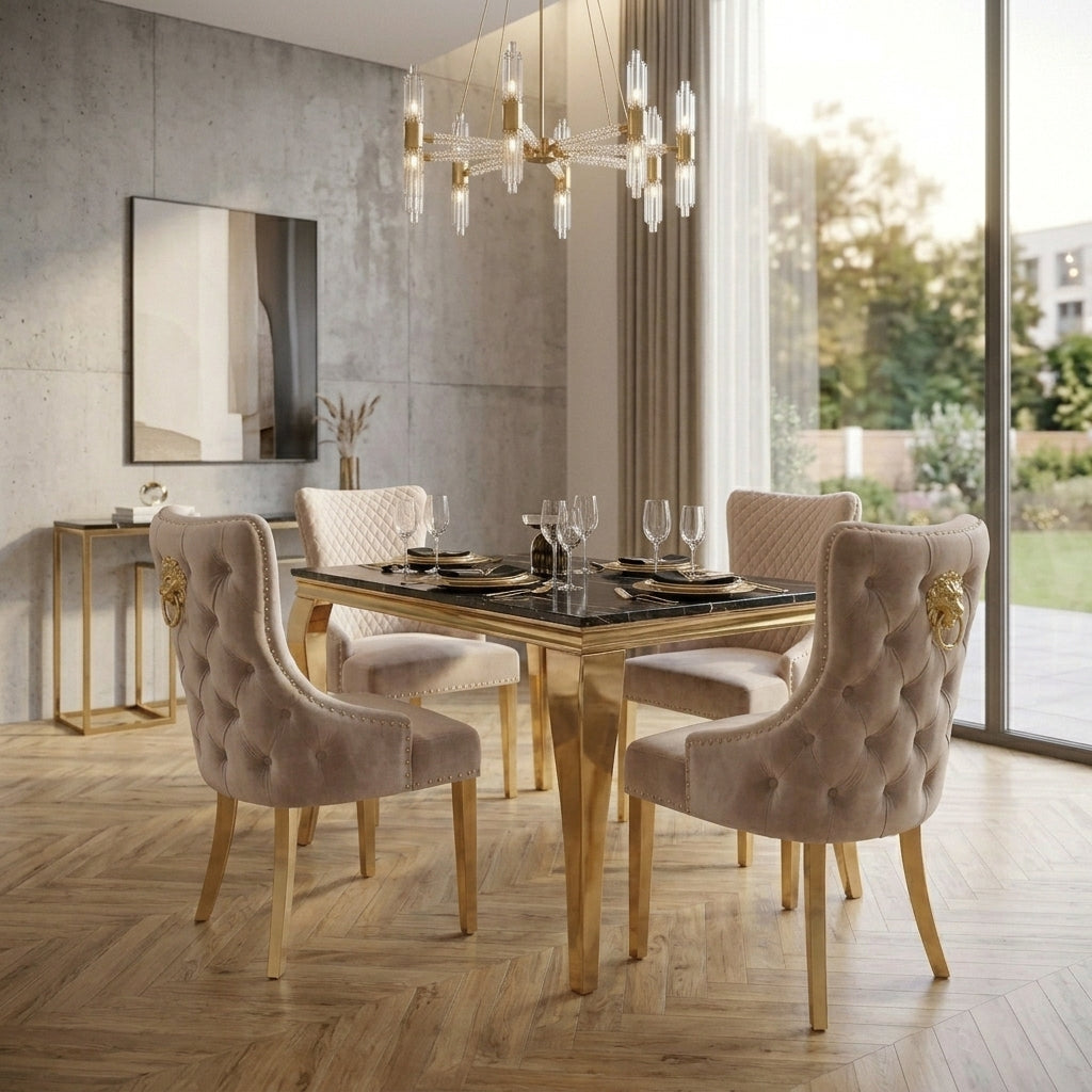 A luxury dining set featuring a rectangular black glass-top table with a gold frame and four tufted blush pink velvet chairs with gold lion head accents on the backrests, set in a modern dining room with wood floors and a concrete wall.