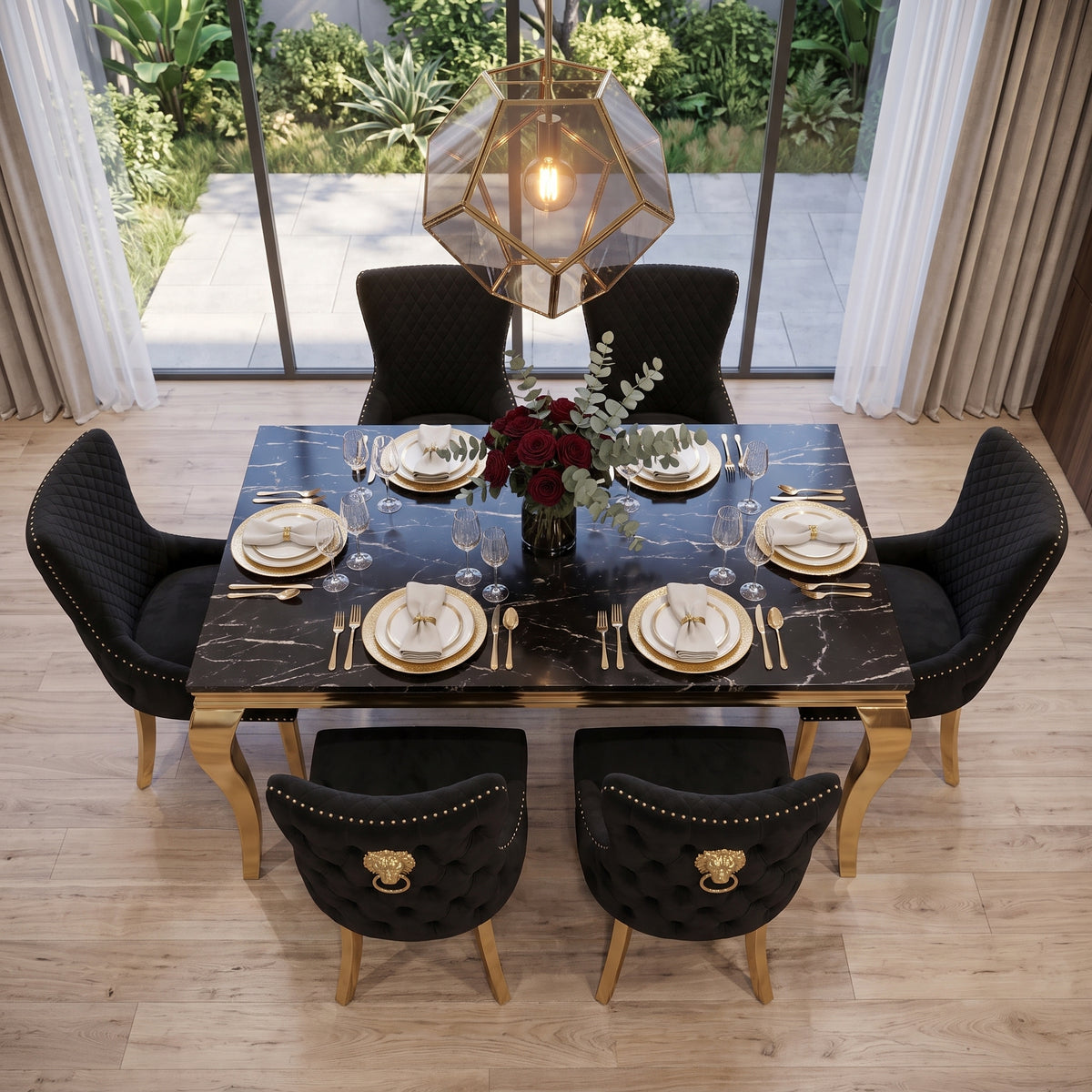 A luxury dining room setup featuring a rectangular black marble dining table with gold legs, surrounded by six black tufted velvet chairs with gold lion-head handles. The table is set with gold-rimmed white plates, gold cutlery, and wine glasses, with a central floral arrangement.