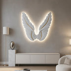 Decorative wall sculpture of angel wings with LED lighting in a modern living room.