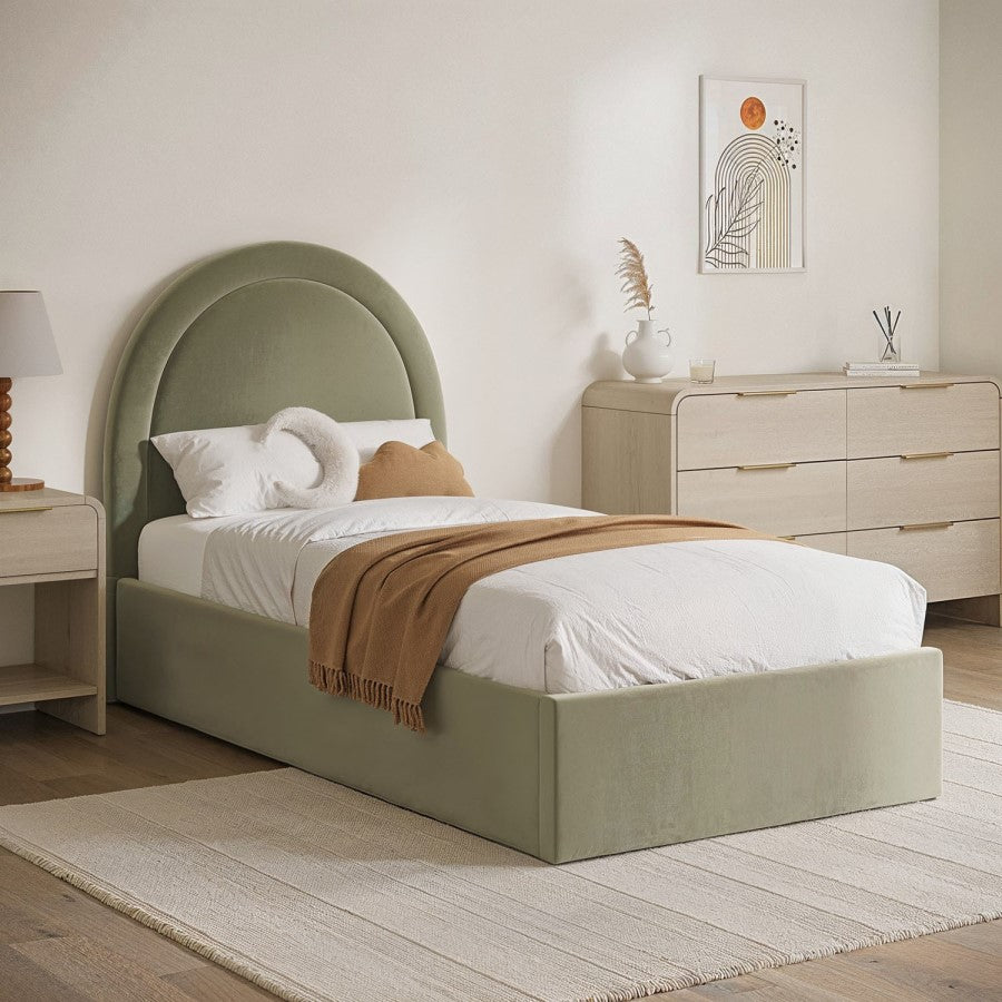 Neatly made bed with green headboard in a bedroom setting.