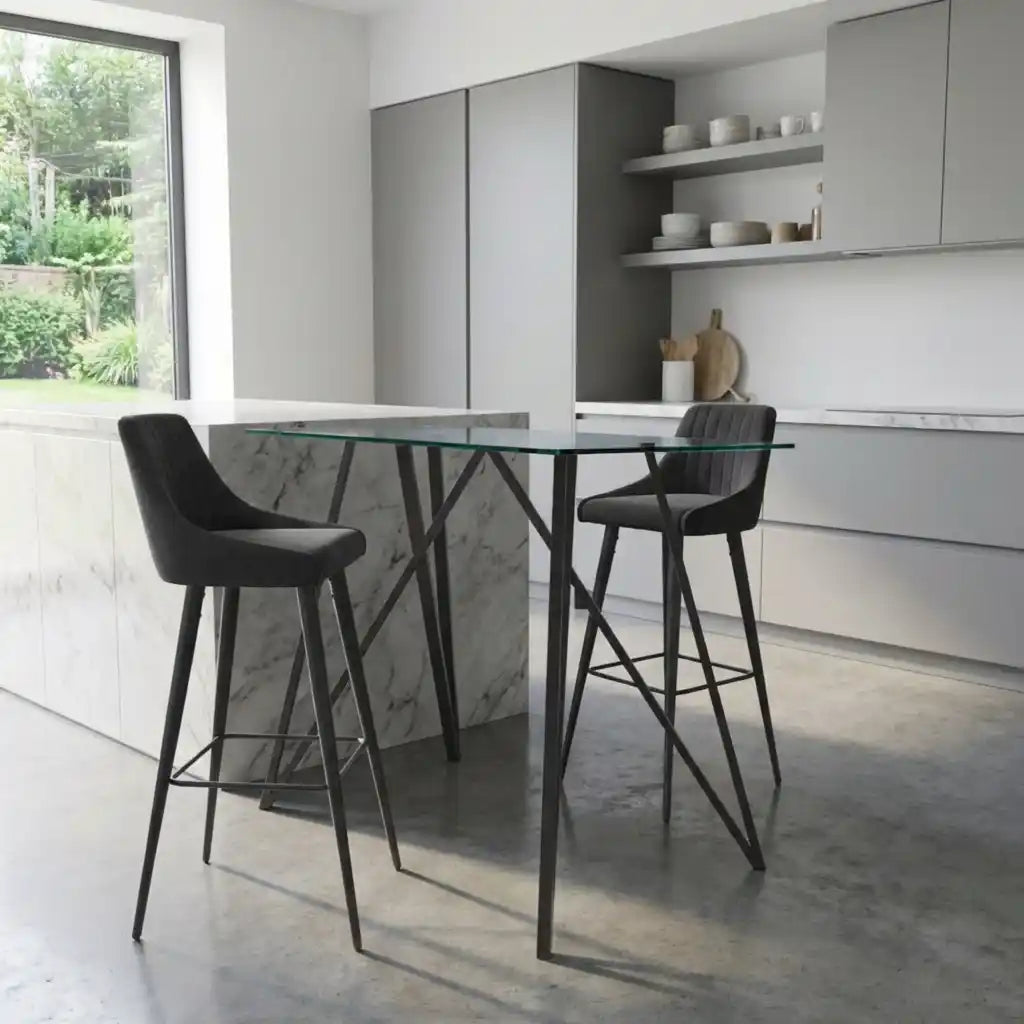 Modern kitchen with a glass island and black bar stools.