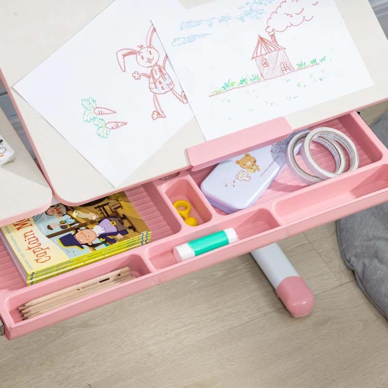 Pink art kit with drawing supplies on a wooden surface