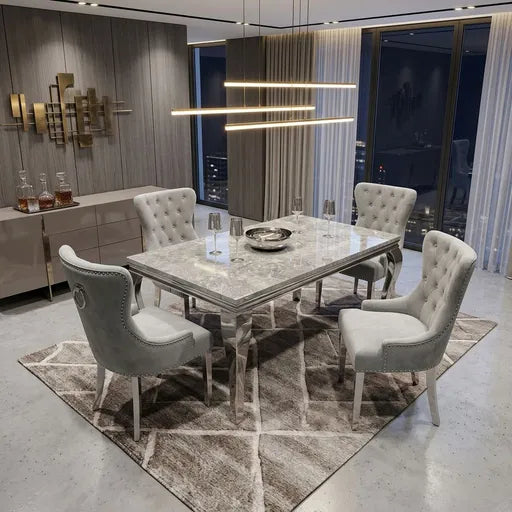 A modern dining room set featuring a rectangular marble-patterned dining table surrounded by four tufted light gray upholstered armchairs, placed on a geometric area rug in a contemporary interior.