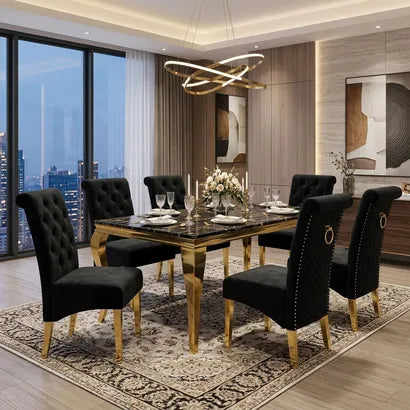 A modern dining room set featuring a rectangular marble-top table with gold legs, surrounded by six black tufted velvet chairs with gold legs, set on a patterned area rug in a luxury dining room.