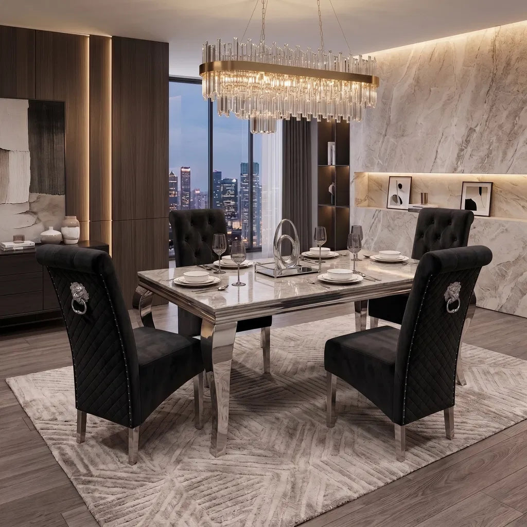 A luxury modern dining room set featuring a rectangular mirrored table with a light marble top, surrounded by four black tufted velvet chairs with silver lion head ring pulls. The set is styled on a patterned rug with a large crystal chandelier overhead and a city skyline window in the background.