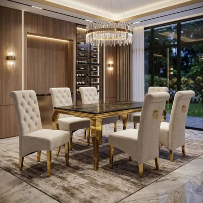 A luxury dining room set featuring a rectangular table with a polished black marble top and gold frame, surrounded by six tufted cream upholstered chairs with gold legs, set on a patterned rug under a crystal chandelier.