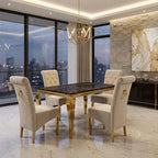 A luxury dining set featuring a rectangular table with a black marble top and gold legs, surrounded by four high-back cream tufted chairs with gold accents, set in a modern dining room with large windows overlooking a city skyline.