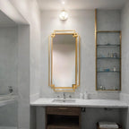 Bathroom with a gold-framed mirror and shelves.