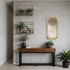 Modern interior with a wooden console table, gold mirror, and potted plants against a gray wall.