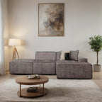 Modern living room with a gray sectional sofa, wooden coffee table, and abstract painting on the wall.