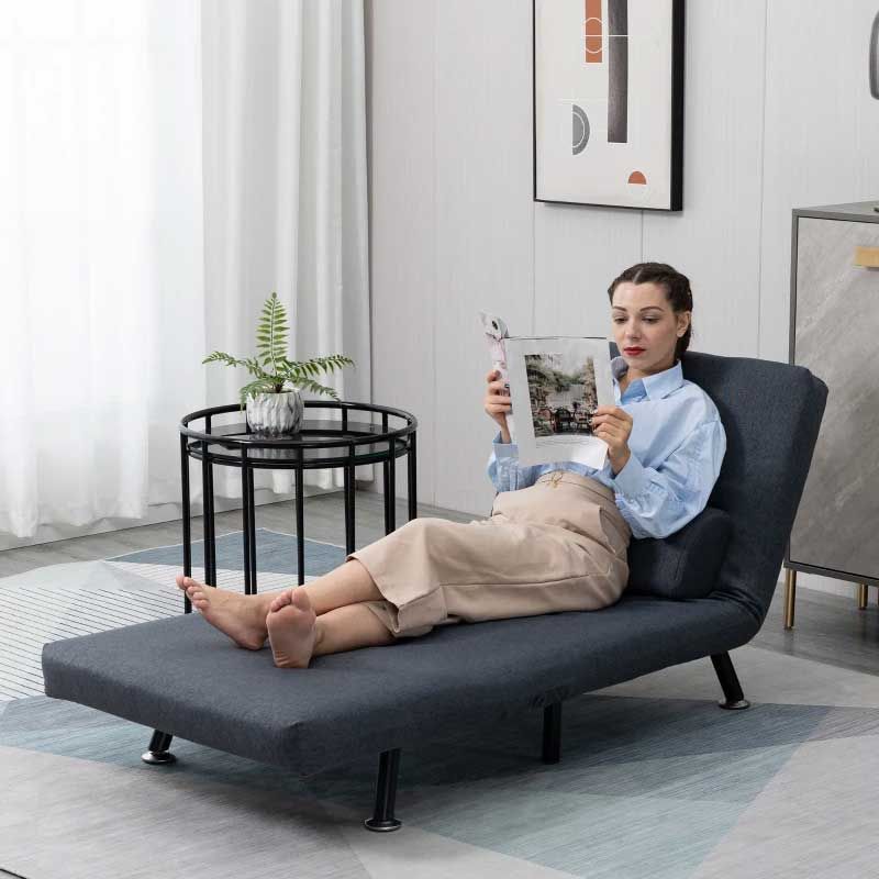 Woman lying on a gray sofa bed in a modern living room.