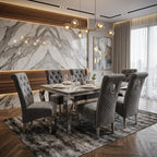 A modern dining room set featuring a rectangular marble-top dining table surrounded by six gray tufted and quilted velvet chairs, placed on a textured gray rug in front of a large marble-patterned wall.