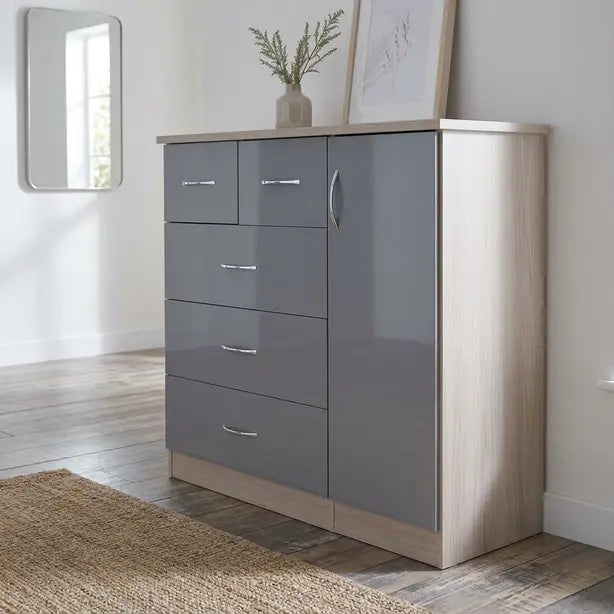 A modern 5-drawer chest of drawers in a gray and light wood finish, styled in a bright room with a mirror, framed art, and a woven rug.