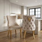 Two elegant dining chairs tufted cream upholstery with a prominent gold lion emblem on the backrest and gold legs.
