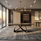 A modern dining table with a dark stone top and sculptural curved metal base