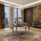 A modern round dining table with a dark marble top and ornate silver legs, styled in a contemporary dining room with a geometric pendant light, large windows, and wood-paneled walls.
