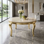 A round marble-top dining table with ornate gold legs