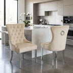 Two elegant dining chairs upholstered in cream tufted velvet with silver nailhead trim and chrome legs, positioned in a modern kitchen setting.