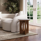Modern living room with a white sofa, wooden side table, and large windows.