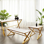 Modern living room with gold-finished coffee table, bench, and side table against white curtains.