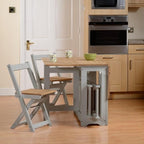 Kitchen with wooden cabinets, a sink, and a small table with chairs.