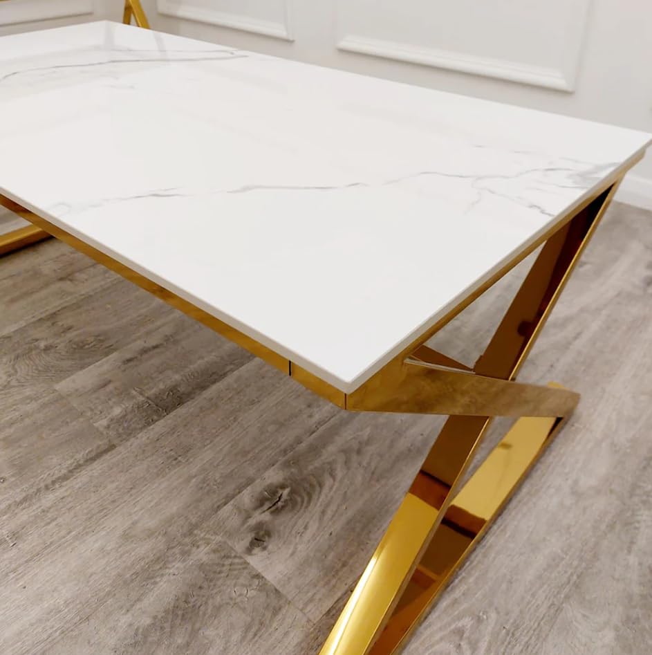 Dining table with marble top and gold metal legs on a wooden floor.