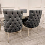 Two gray tufted chairs in a dining room setting.