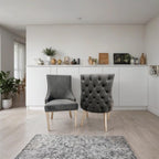 Modern interior with two gray chairs in a room with white walls and light wood flooring.