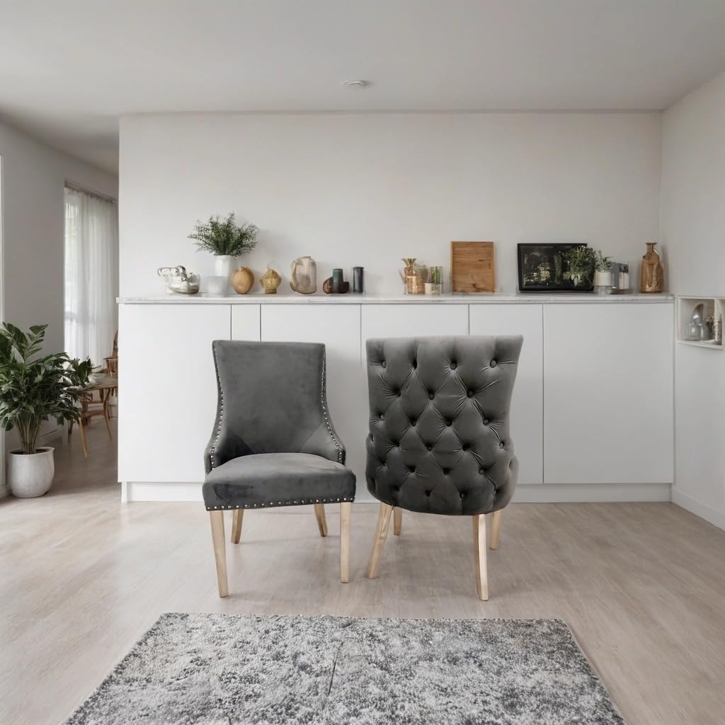 Modern interior with two gray chairs in a room with white walls and light wood flooring.