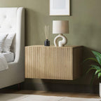 Wooden nightstand with decorative items next to a bed in a bedroom setting.